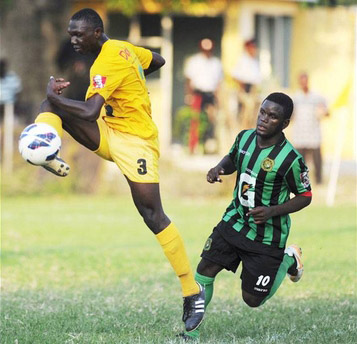 Excelsior High School's Hishrock Francis (left) kicks the ball while Calabar High's Kyle Scott tussles for possession during the ISSA/Gatorade/Digicel Manning Cup second-round football match at Constant Spring Complex yesterday. Excelsior won 2-0 - Ricardo Makyn/Staff Photographer