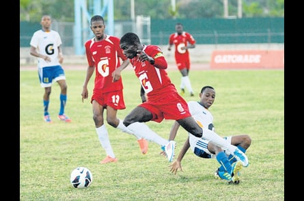 Glenmuir High’s Kamal Henry (foreground) evades a challenge from STETHS Carl Campbell (right) during their schoolboy daCosta Cup final at Montego Bay Sports Complex yesterday. Glenmuir won 1-0. (Photo: Paul Reid) 