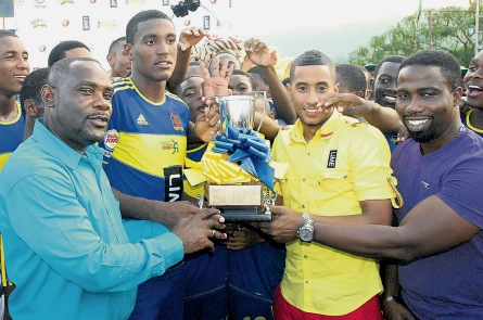 Dr Walton Small (left, foreground), president of ISSA; Stephen Miller (second right), of LIME; and Wisynco’s Jermaine Brown (right) present the ISSA/LIME Ben Francis KO trophy to Romario Thompson, captain of STETHS, after they beat Manchester High 2-0 in the final played at the STETHS Sports Complex yesterday.(PHOTO: PAUL REID)